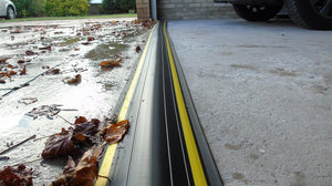 Installed 40mm garage door water barrier protecting a garage from water and leaves