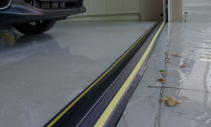 Garage with water and leaves outside protected on the inside by 40mm garage door water barrier